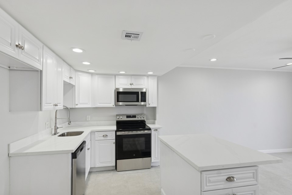 2016 Main Street, Unit 2507 Houston, TX 77002 - Photo 8 of 32 a kitchen with stainless steel appliances a sink dishwasher a stove top oven a refrigerator with white cabinets and a wooden floor