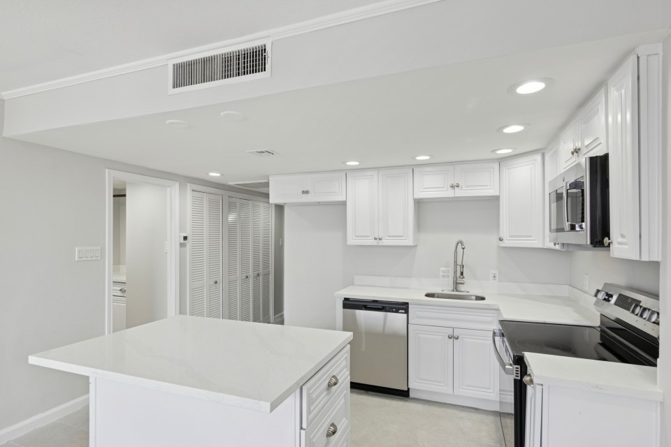 2016 Main Street, Unit 2507 Houston, TX 77002 - Photo 9 of 32 a kitchen with white cabinets and white appliances