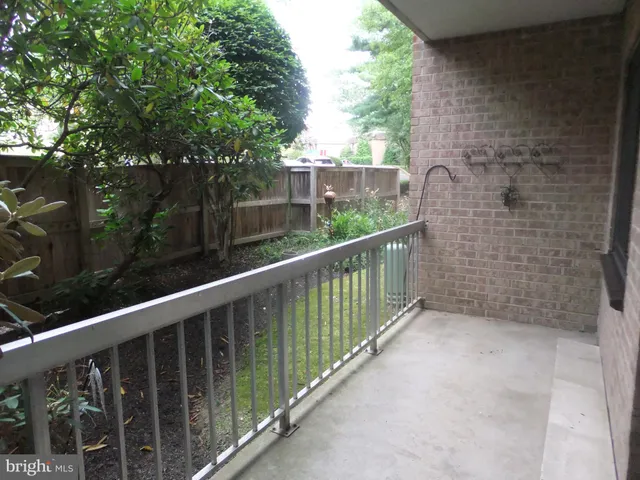 a view of swimming pool with outdoor seating and trees in the background