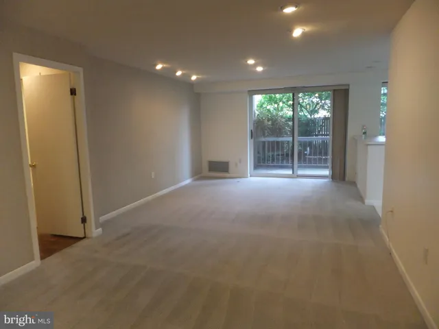 a view of empty room with kitchen