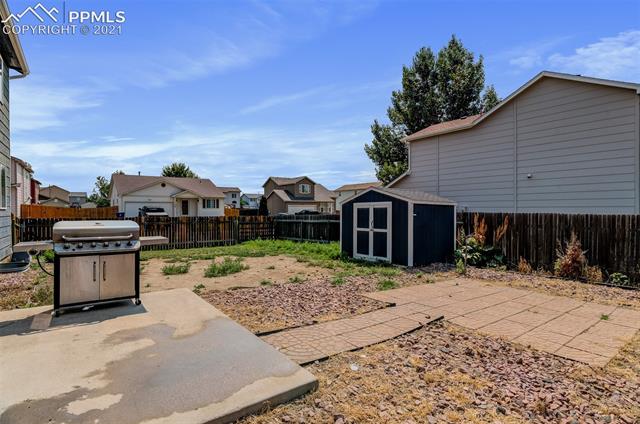 11127 Berry Farm Road Fountain, CO 80817 - Photo 18 of 19 Backyard has two patio spaces and a storage shed