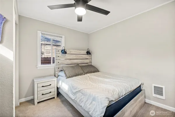 a bed room with a bed and a ceiling fan