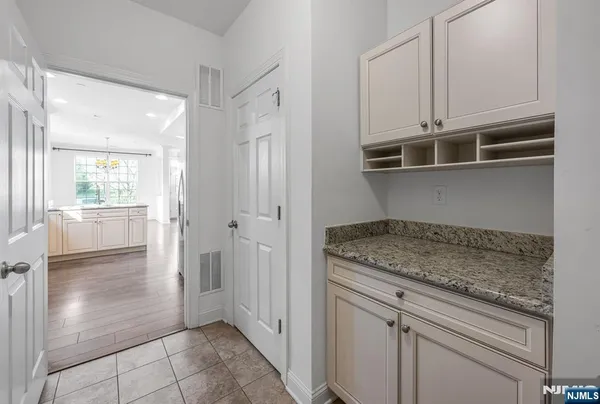 a kitchen with white cabinets and a window