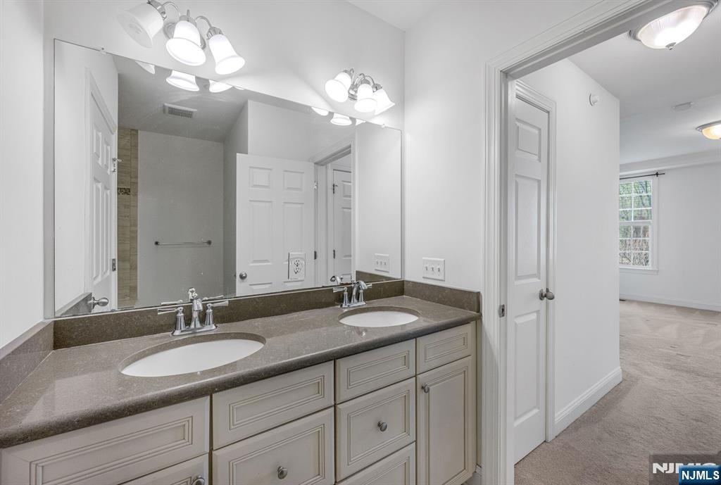 63 Autumn Way, Unit 35 Montvale, NJ 07645 - Photo 16 of 27 a bathroom with a granite countertop sink a light fixture and a mirror