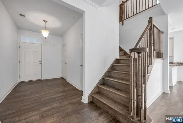 a view of entryway and hall with wooden floor