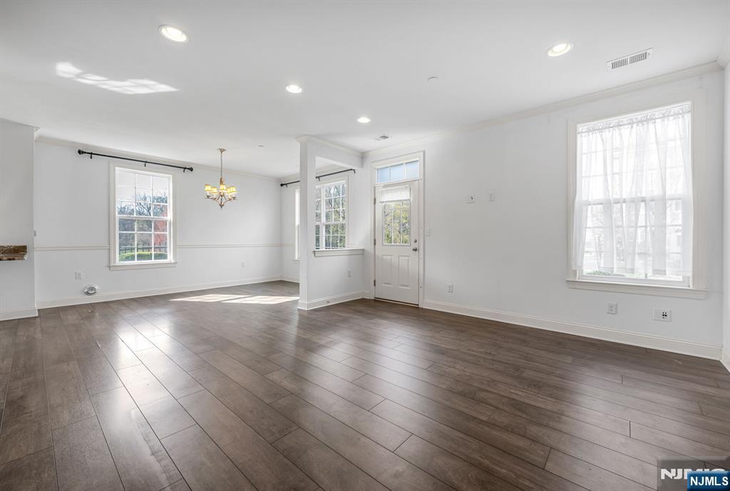 63 Autumn Way, Unit 35 Montvale, NJ 07645 - Photo 3 of 27 an empty room with wooden floor and windows with curtains view