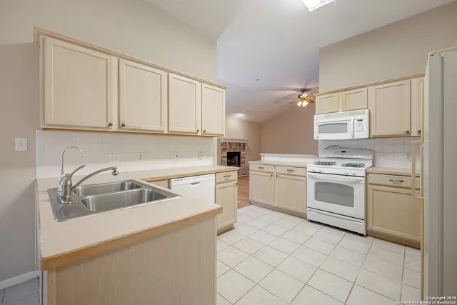 a kitchen with white cabinets and white appliances
