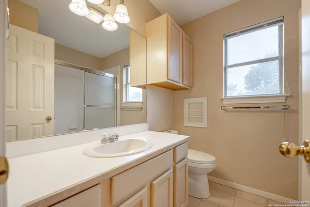 a bathroom with a sink a toilet and a mirror