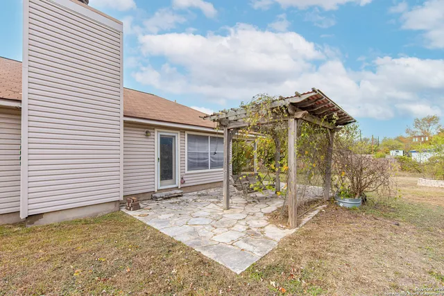 a view of a house with a backyard and a tree