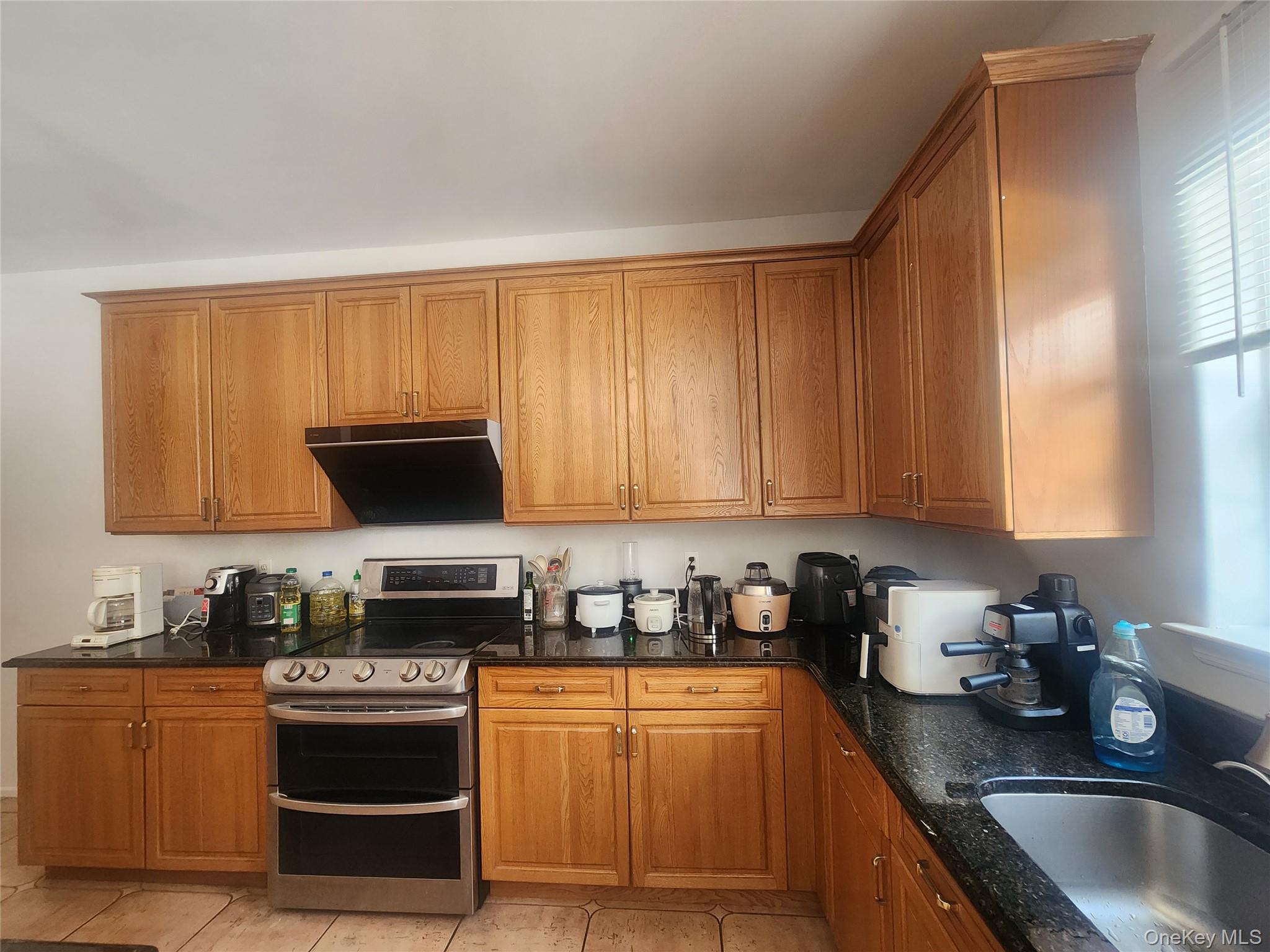 3 Arbor Field Way Lake Grove, NY 11755 - Photo 3 of 12 a kitchen with granite countertop a sink a stove top oven and cabinetry