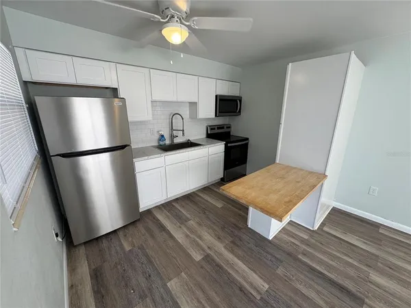 a kitchen with stainless steel appliances a refrigerator sink and microwave