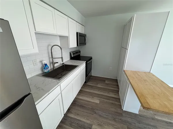 a kitchen with sink a stove and cabinets