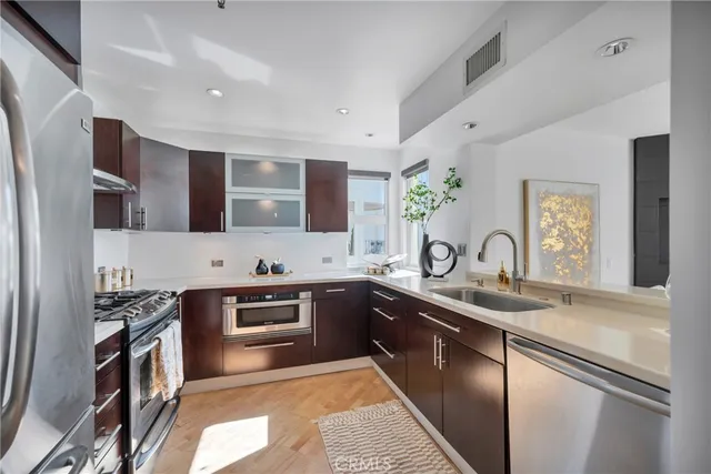 a kitchen with stainless steel appliances granite countertop a sink stove and refrigerator