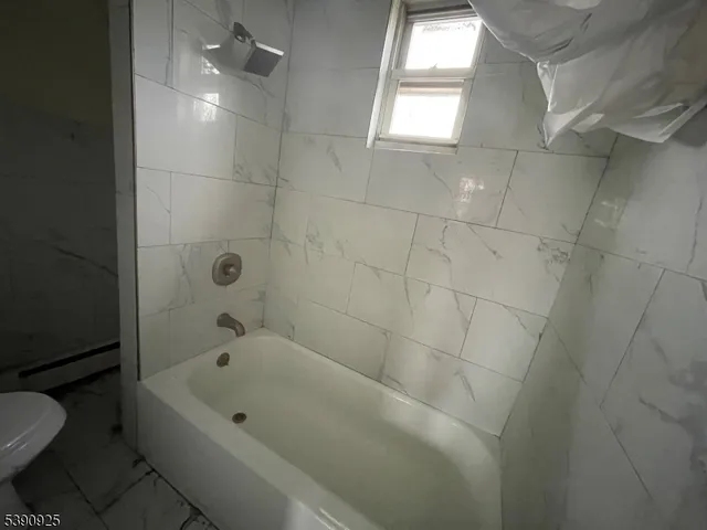 a bathroom with a bathtub and toilet