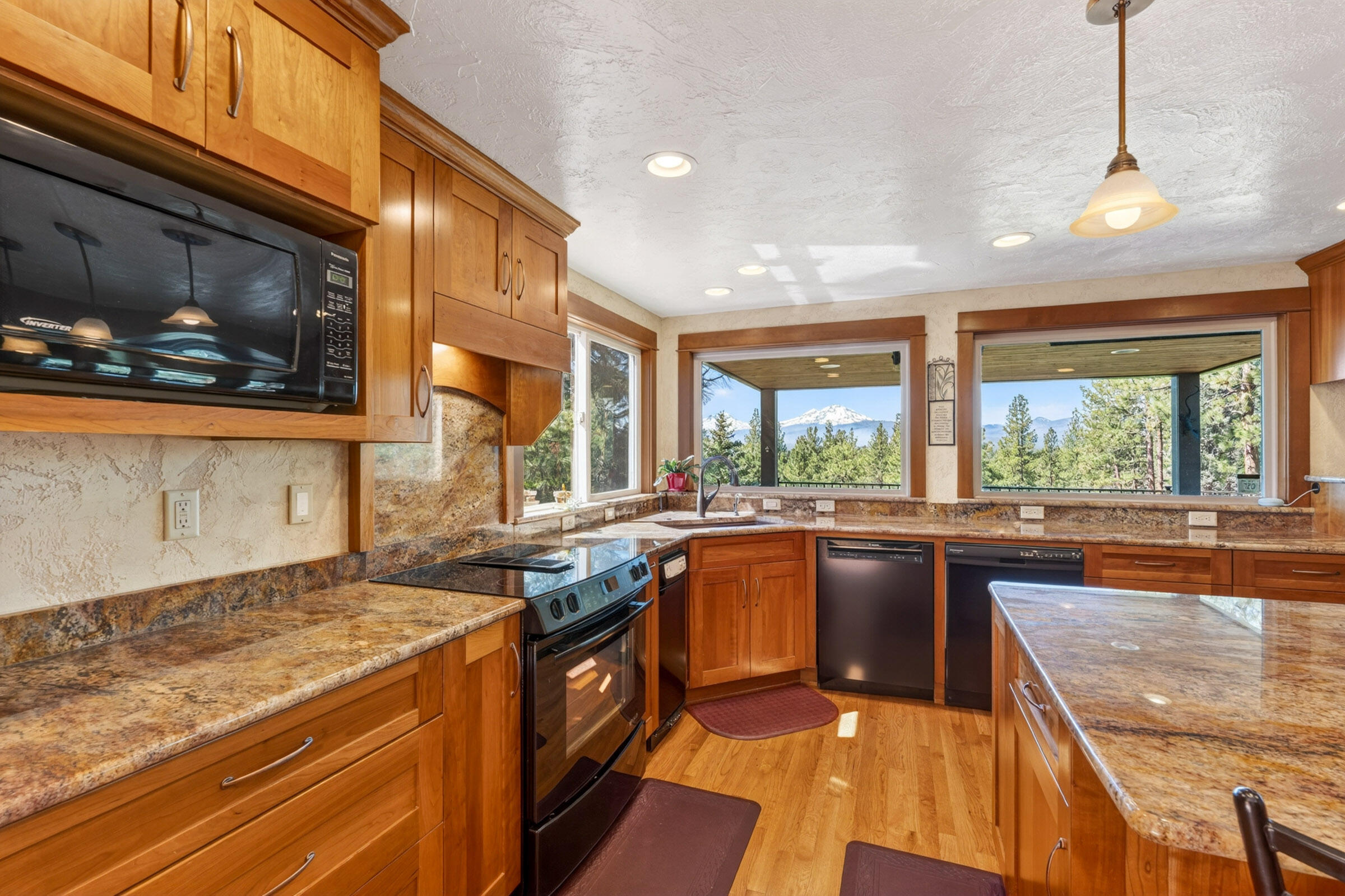 69470 Deer Ridge Road Sisters, OR 97759 - Photo 11 of 96 a kitchen with stainless steel appliances granite countertop a stove a sink and a microwave