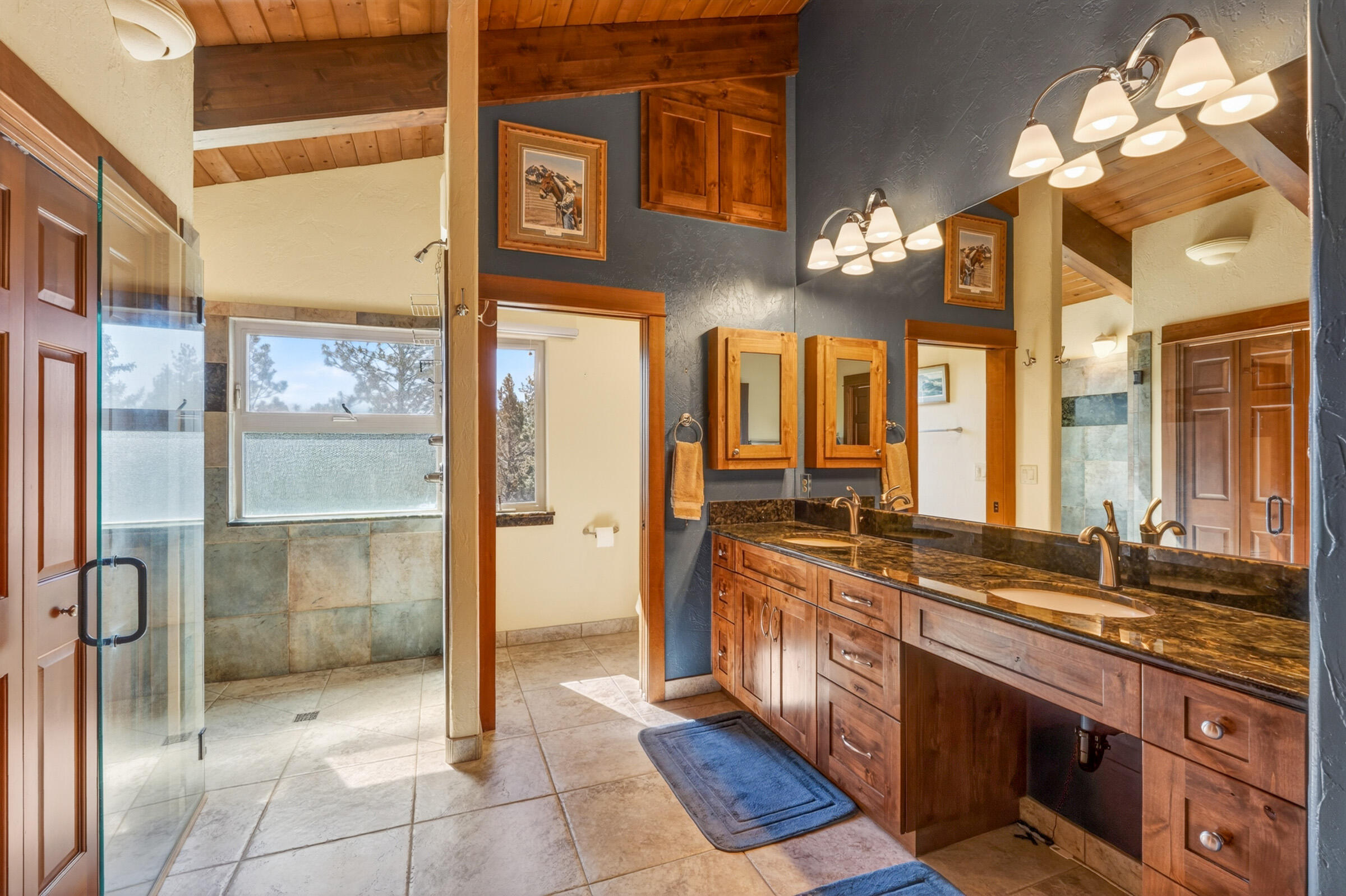 69470 Deer Ridge Road Sisters, OR 97759 - Photo 38 of 96 a spacious bathroom with a double vanity sink a mirror and a shower