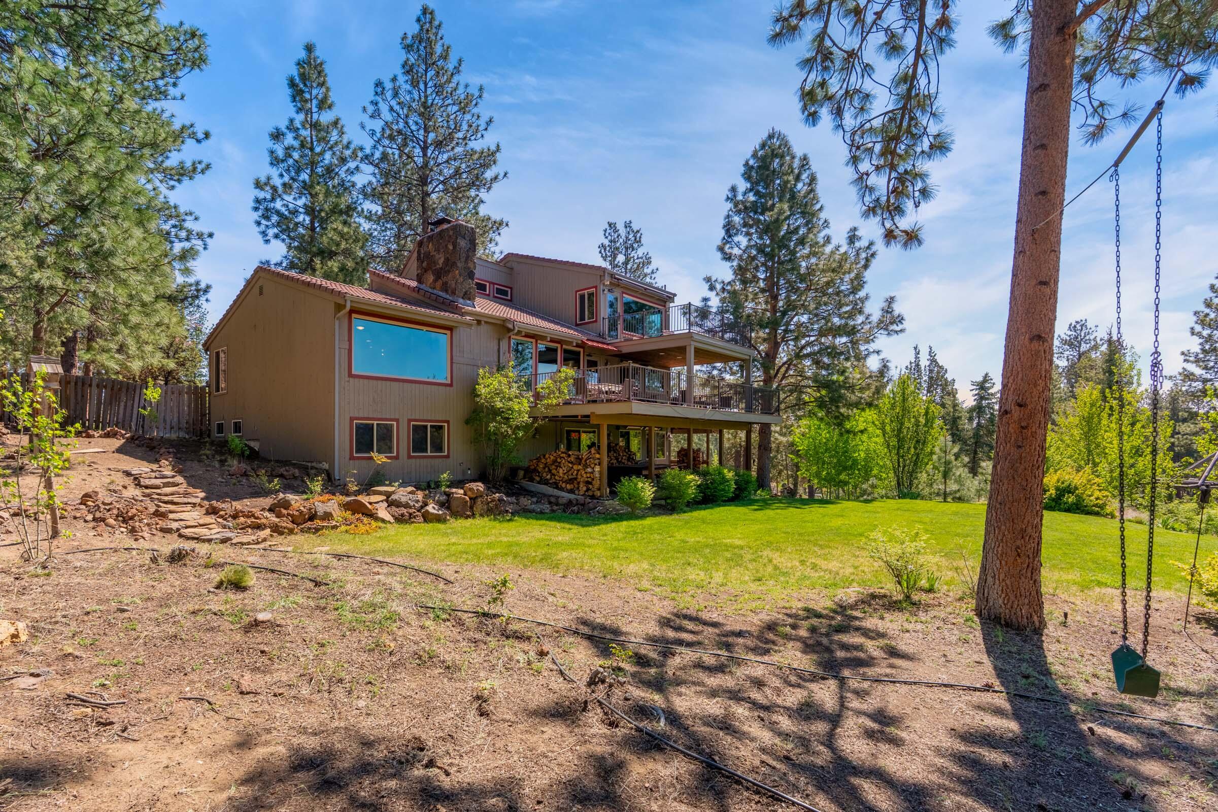 69470 Deer Ridge Road Sisters, OR 97759 - Photo 67 of 96 a front view of house with yard and trees in the background