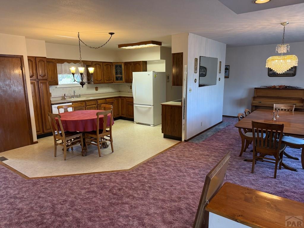 65281 Highway 50 Fowler, CO 81039 - Photo 14 of 16 a kitchen with stainless steel appliances kitchen island granite countertop dining table chairs and a refrigerator