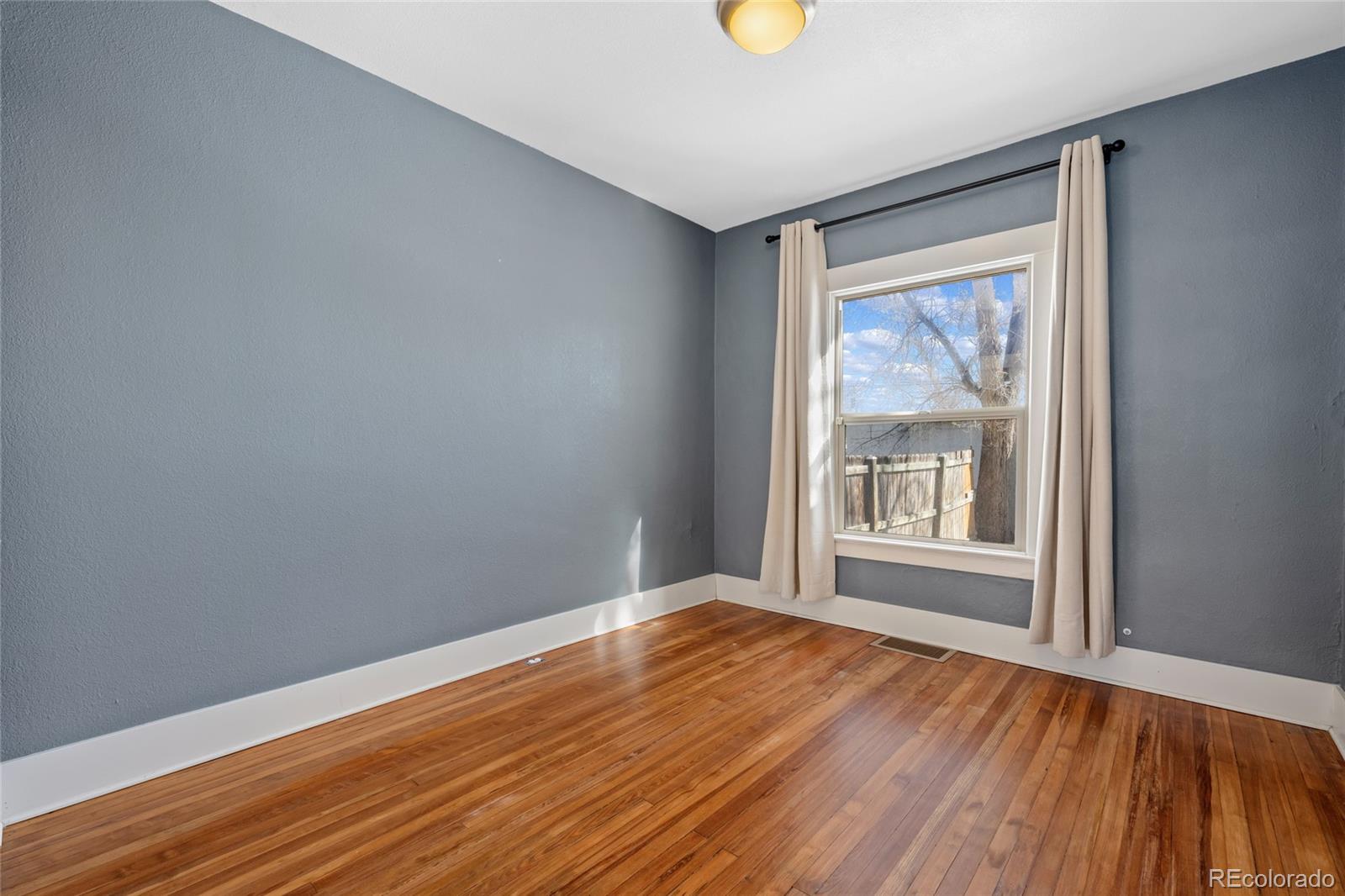 3340 Decatur Street Denver, CO 80211 - Photo 14 of 29 a view of an empty room with wooden floor and a window
