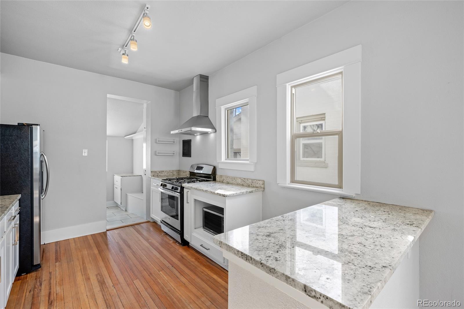 3340 Decatur Street Denver, CO 80211 - Photo 10 of 29 a kitchen with stainless steel appliances granite countertop a stove and a refrigerator