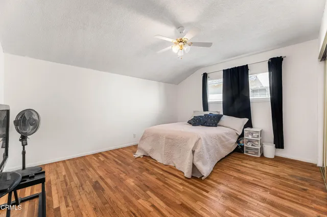 a bedroom with a bed and wooden floor