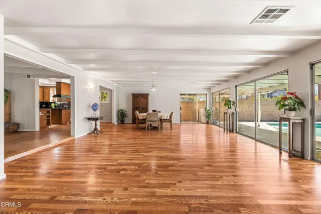 a living room with furniture a flat screen tv and a floor to ceiling window