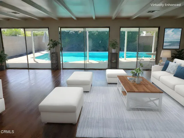 a kitchen with stainless steel appliances granite countertop a stove a refrigerator a sink a dining table and chairs with wooden floor