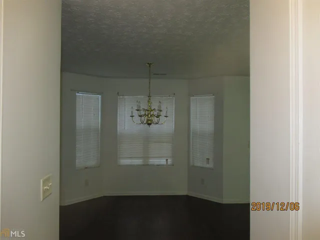 a view of a small space with wooden floor and a window