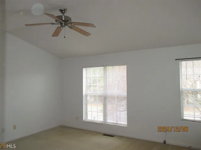 an empty room with a fan and a window