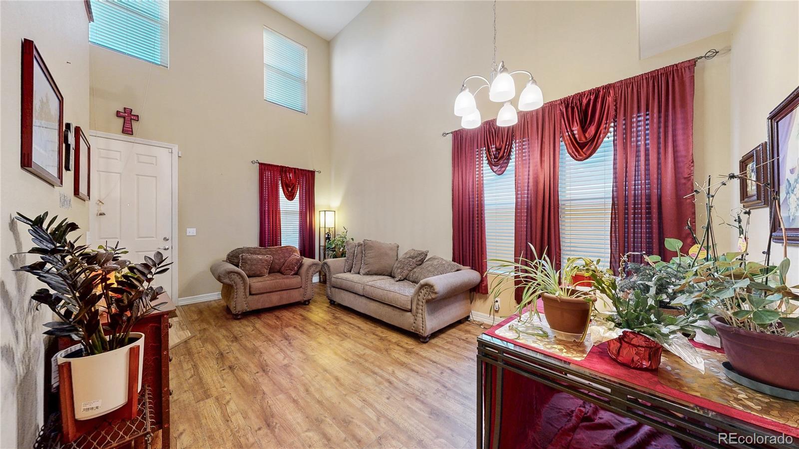 16159 Randolph Place Denver, CO 80239 - Photo 5 of 37 a living room with furniture and a chandelier