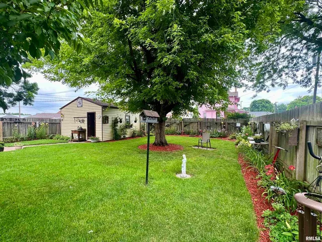 a house view with a play ground and large trees