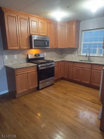 a kitchen with stainless steel appliances granite countertop a stove a sink and a microwave