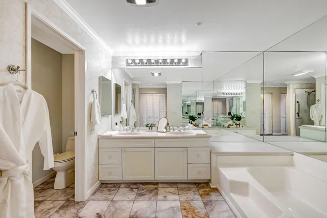 a large bathroom with a double vanity sink a mirror and a bathtub