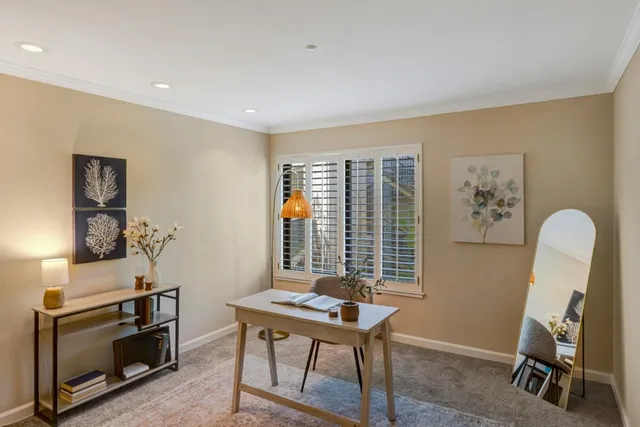 a view of a workspace with furniture and a window
