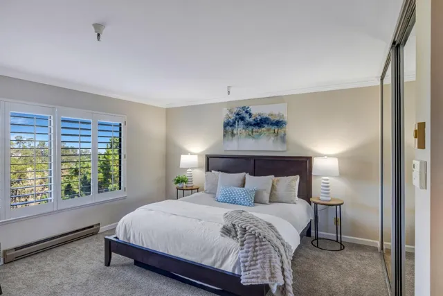 a bedroom with a bed and a painting on the wall