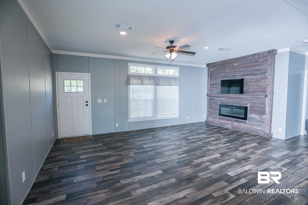 19180 Horseshoe Circle Seminole, AL 36574 - Photo 3 of 38 Unfurnished living room with ornamental molding, dark wood-type flooring, a ceiling fan, a large fireplace, and recessed lighting