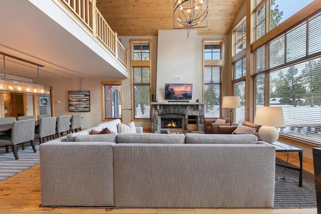a living room with furniture a fireplace and a large window