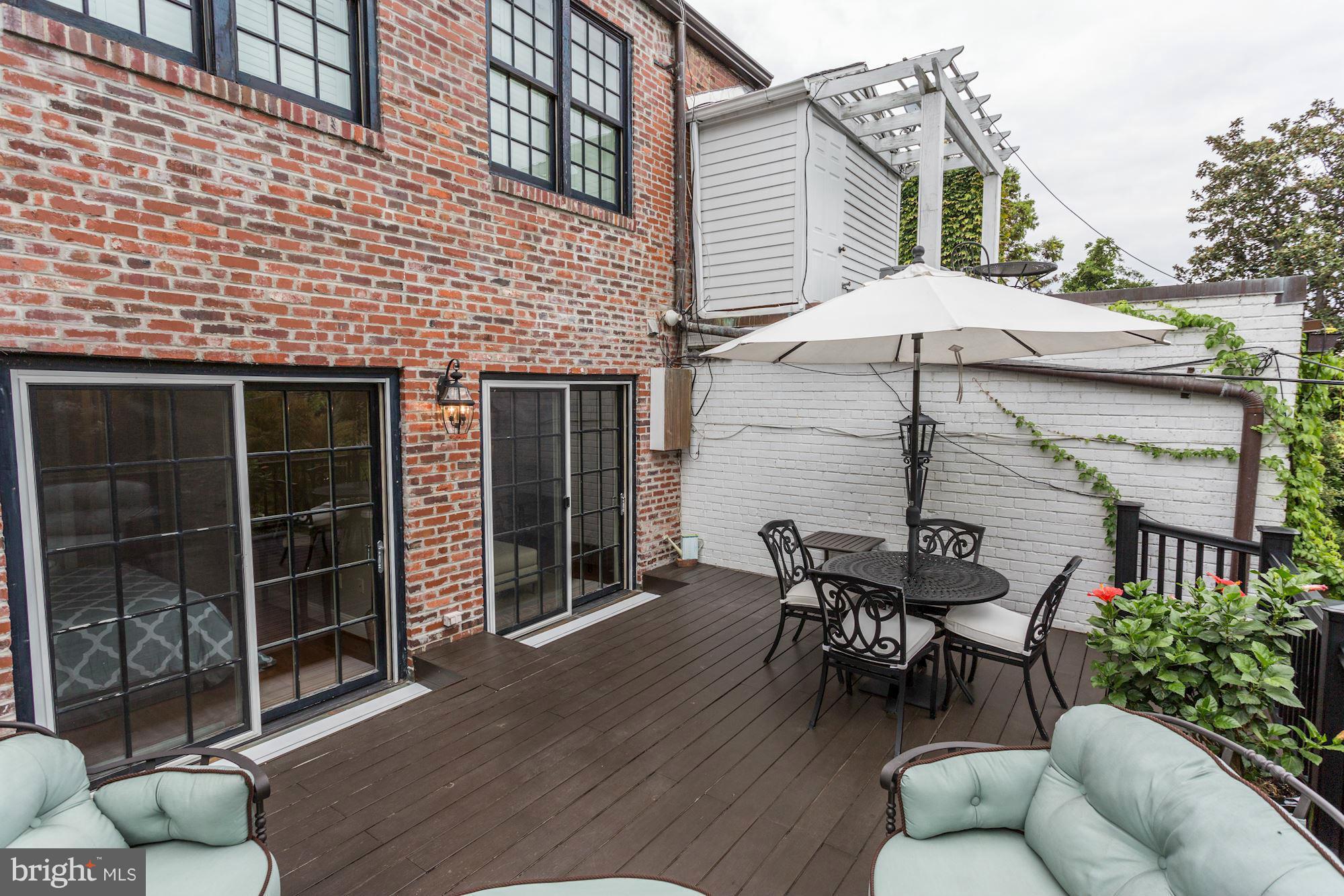 3318 Volta Place Northwest, Unit 2 Washington, DC 20007 - Photo 30 of 30 a patio with a table and chairs under an umbrella