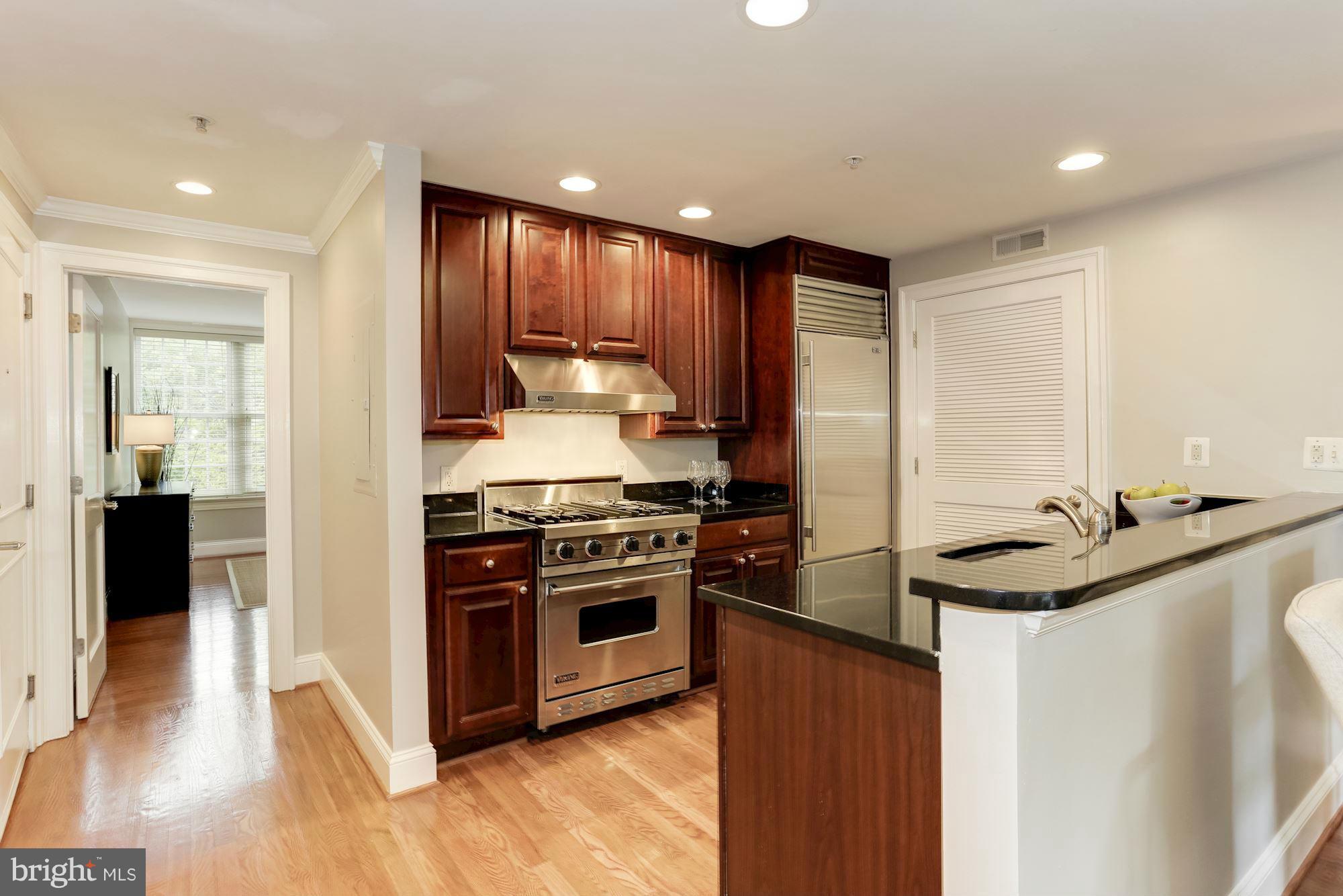3318 Volta Place Northwest, Unit 2 Washington, DC 20007 - Photo 4 of 30 a kitchen with stainless steel appliances granite countertop a sink stove and refrigerator