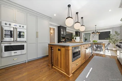 a kitchen with stainless steel appliances a stove and a wooden floor