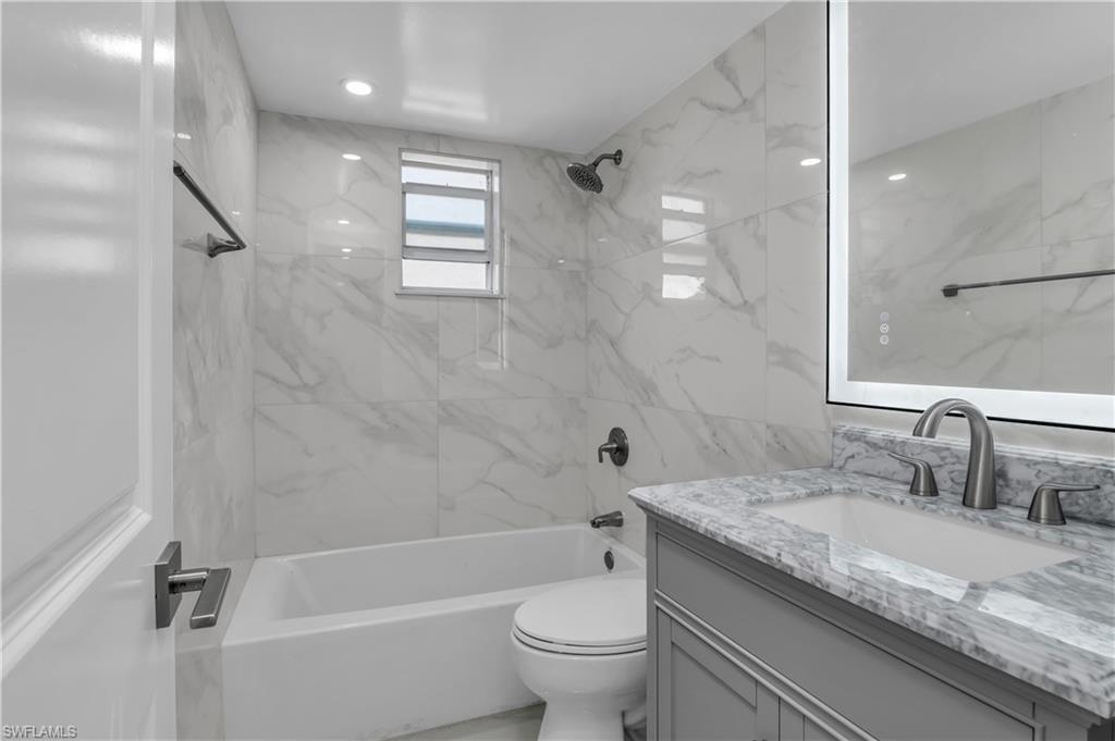 3325 Airport Road North, Unit T1 Naples, FL 34105 - Photo 12 of 19 a bathroom with a granite countertop sink a toilet and shower