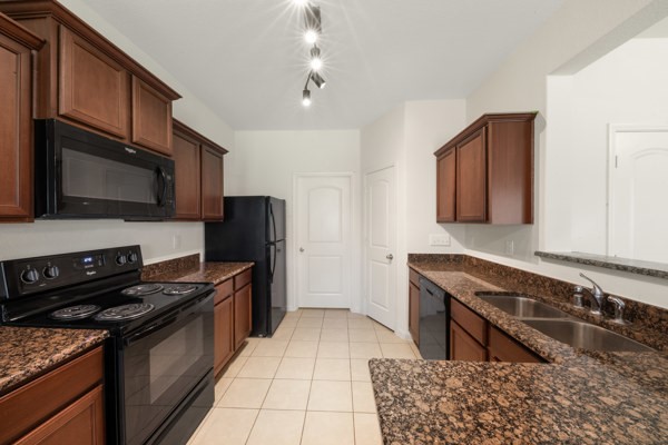1327 Diamond Drape Drive Rosharon, TX 77583 - Photo 8 of 26 a kitchen with stainless steel appliances granite countertop a stove a sink and a microwave