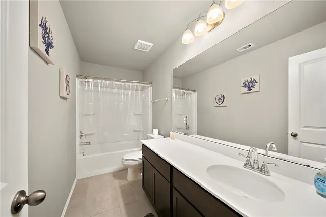 a bathroom with a double vanity sink a toilet and a bathtub