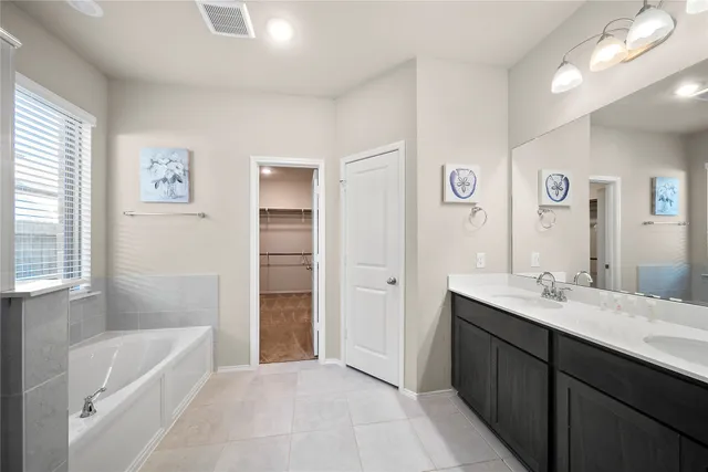 a bathroom with a tub sink and a mirror