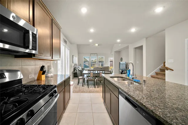 a kitchen with stainless steel appliances granite countertop a stove oven and a sink