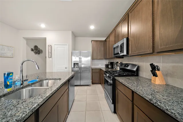 a kitchen with stainless steel appliances granite countertop a sink stove and refrigerator
