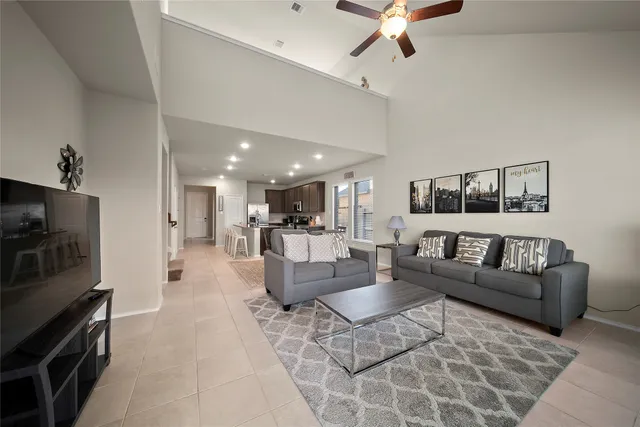 a living room with furniture a flat screen tv and a kitchen