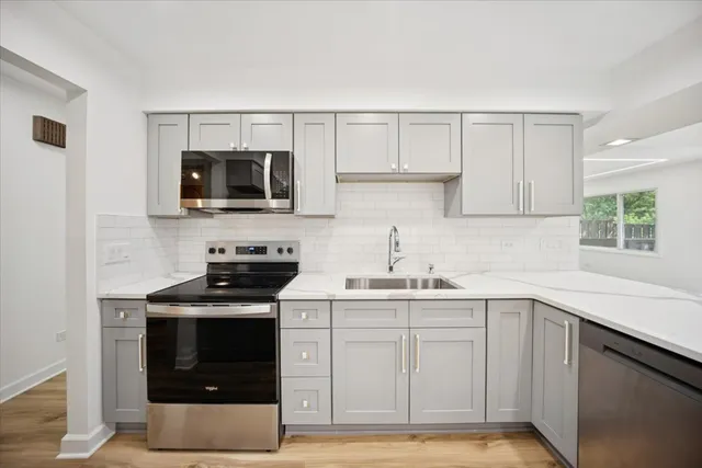 a kitchen with stainless steel appliances a stove microwave and sink