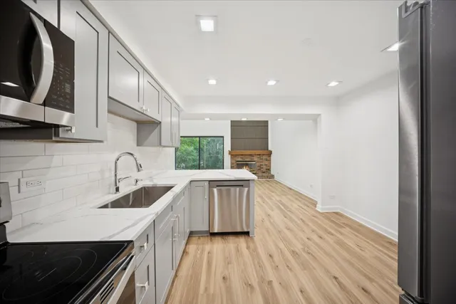 a kitchen with sink a microwave and cabinets