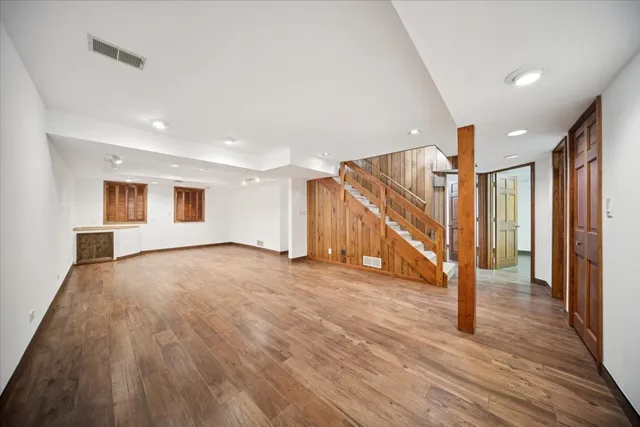 a view of an empty room with wooden floor